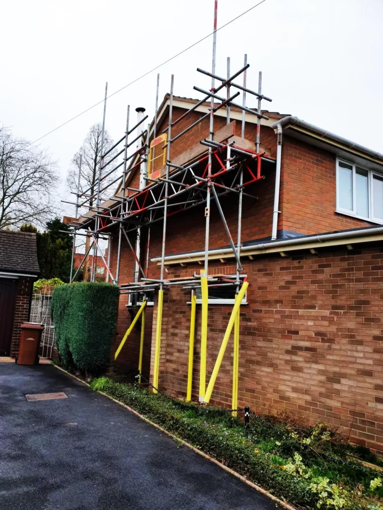Scaffolding on the side of a brick house