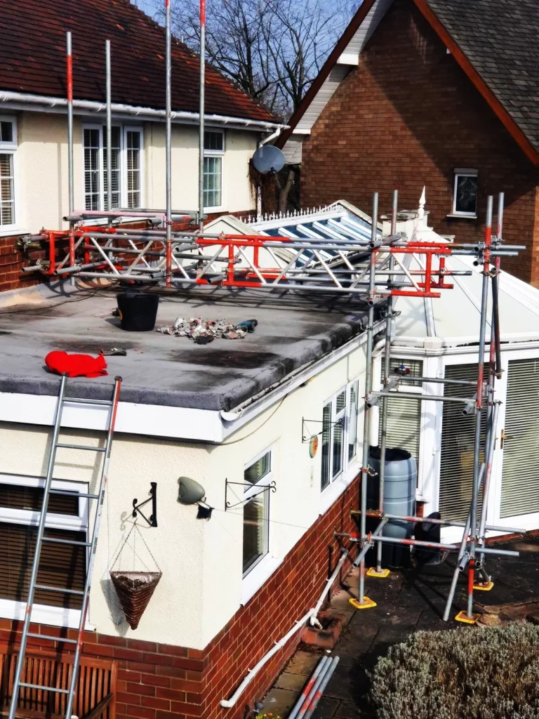 Scaffolding around a flat-roof extension with a ladder