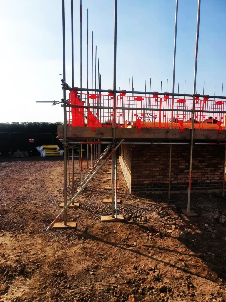 Scaffolding with red safety netting on a new-build site