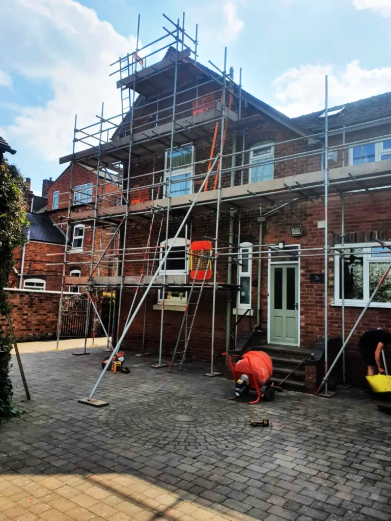 Scaffolding across the front of a brick semi-detached house